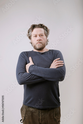 nordic man with serious expression and crossed arms looking at the camera