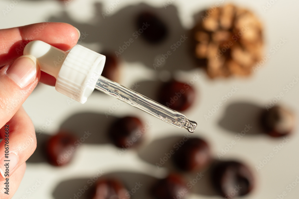 Concept of autumn skincare. Closeup of a facial serum and chestnuts.