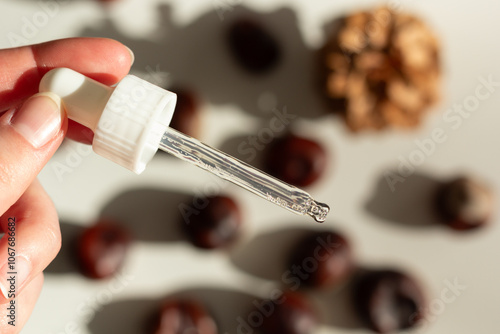 Obraz na płótnie Concept of autumn skincare. Closeup of a facial serum and chestnuts. w salonie