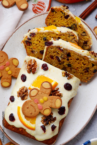 Pumpkin Christmas cake with dried fruits, spices and cheese frosting on a Christmas rustic background