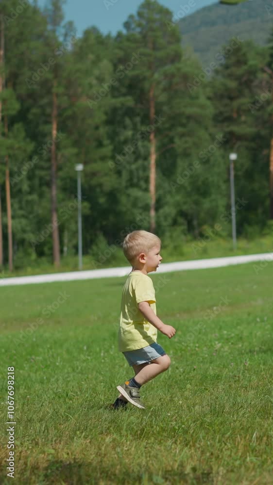 Cute playful toddler boy runs along lush meadow and scratches side spending time in large sunny resort park on summer day slow motion Cute playful toddler boy runs along lush meadow and scratches side spending time in large sunny resort park on summer day slow motion
