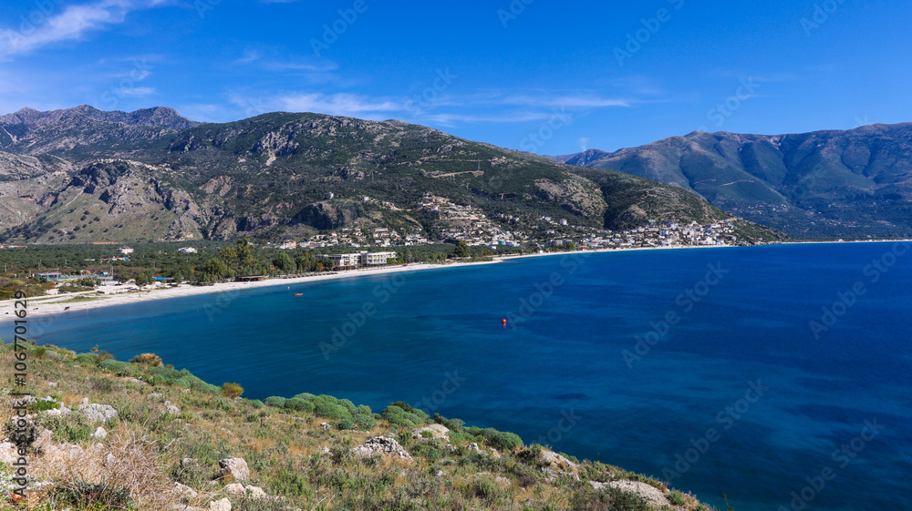 bird's eye view of the wide coast of the Albanian Riviera and its longest beach, Borsh, with a white beach, blue sea and mountains in the background bird's eye view of the wide coast of the Albanian Riviera and its longest beach, Borsh, with a white beach, blue sea and mountains in the background