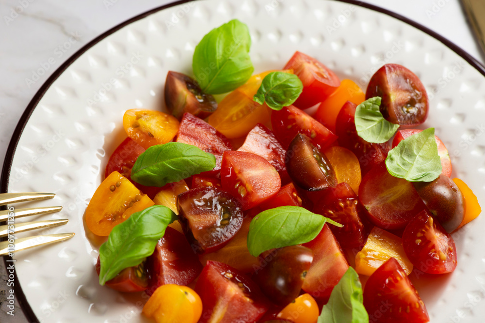 Salad with halves of red and yellow tomatoes cherry with basil Salad with halves of red and yellow tomatoes cherry with basil