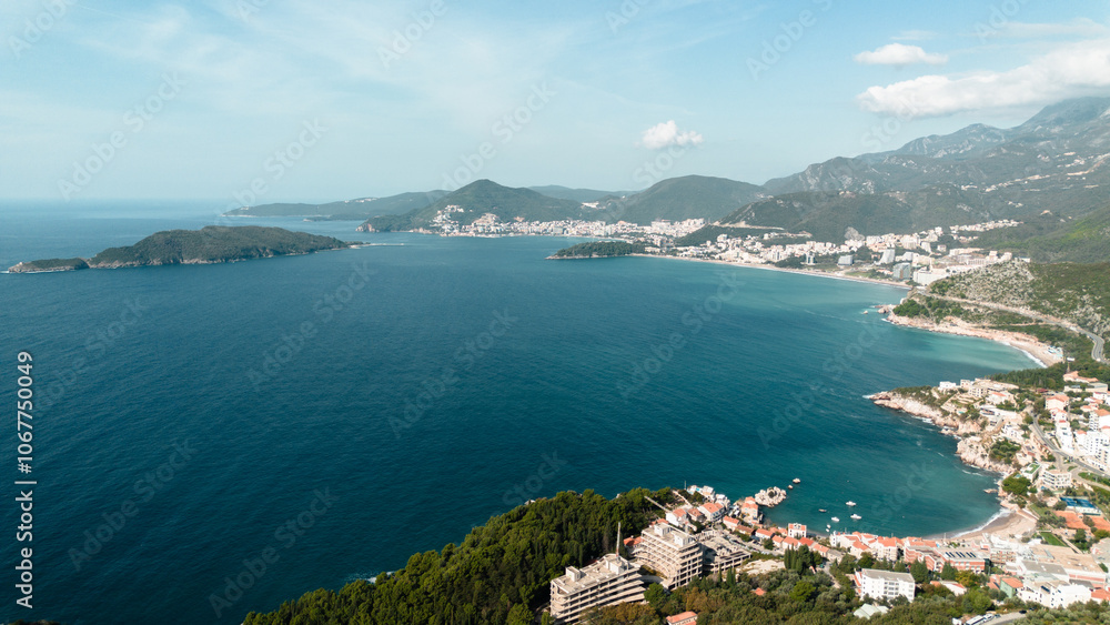Obraz premium Aerial view of St. Nicholas Island and Budva and Becici town from afar. The Adriatic coast in Montenegro. Clear turquoise water. A calm seascape. The resort is popular among tourists.