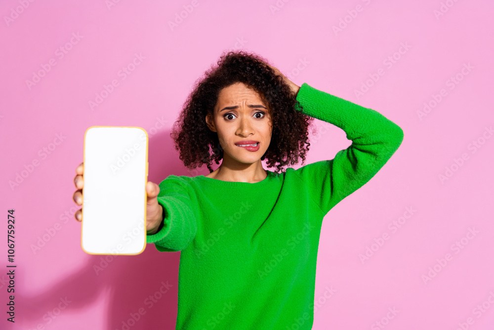 Photo portrait of attractive young woman show white screen device nervous dressed stylish green clothes isolated on pink color background Photo portrait of attractive young woman show white screen device nervous dressed stylish green clothes isolated on pink color background
