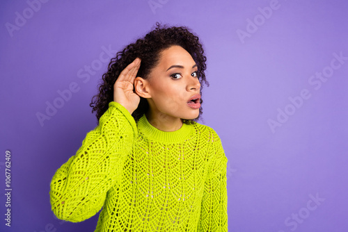 Closeup photo of young funny excited girl with curly hair touching ear trying to hear breaking news isolated on violet color background photo