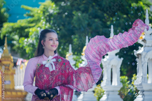 Beautiful Asian woman tourist wearing traditional Thai dress costume. The travel destination is Wat San Payang Luang Temple famous place of tourist attraction in Lamphun, Thailand. Portrait fashion.