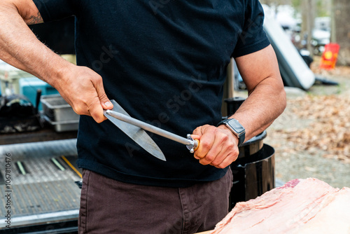 Chef sharpening knives to prepare brisket  photo