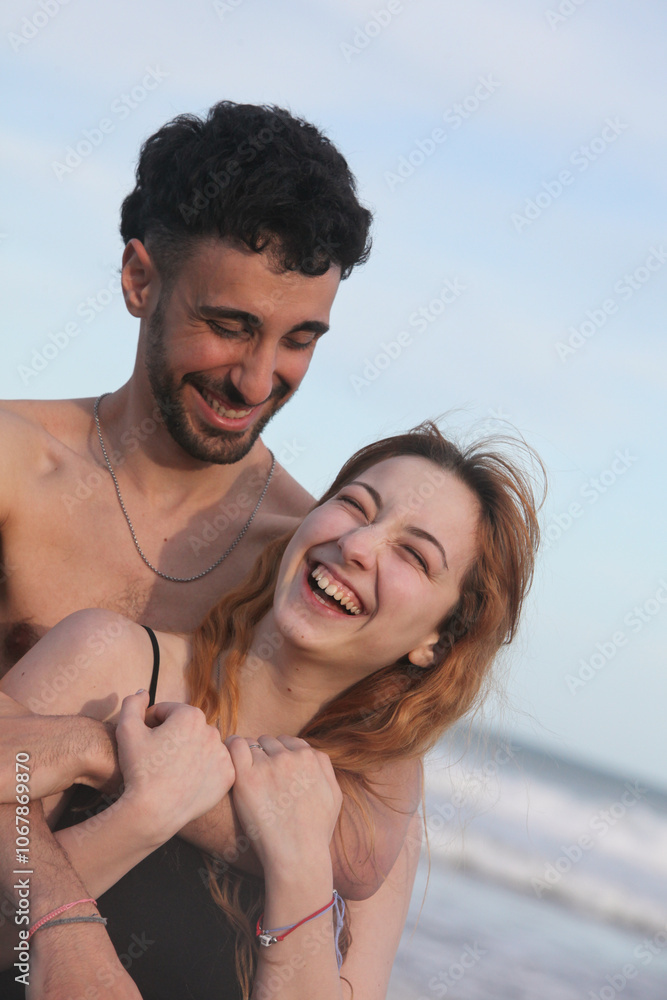 portrait of young cheerful loving couple on the beach on summer day portrait of young cheerful loving couple on the beach on summer day