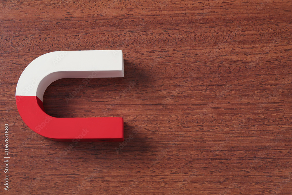 One horseshoe magnet on wooden background, top view. Space for text One horseshoe magnet on wooden background, top view. Space for text