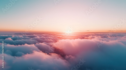 A breathtaking sunset above soft clouds, showcasing vibrant colors that blend beautifully in the sky, creating a tranquil and serene atmosphere.