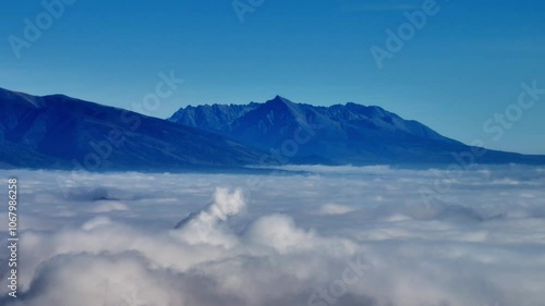 Wallpaper Mural Aerial view featuring the iconic Krivan peak rising above a blanket of clouds in Slovakia. This stunning scene captures the beauty of one of Slovakia’s most cherished mountains under a clear blue sky. Torontodigital.ca