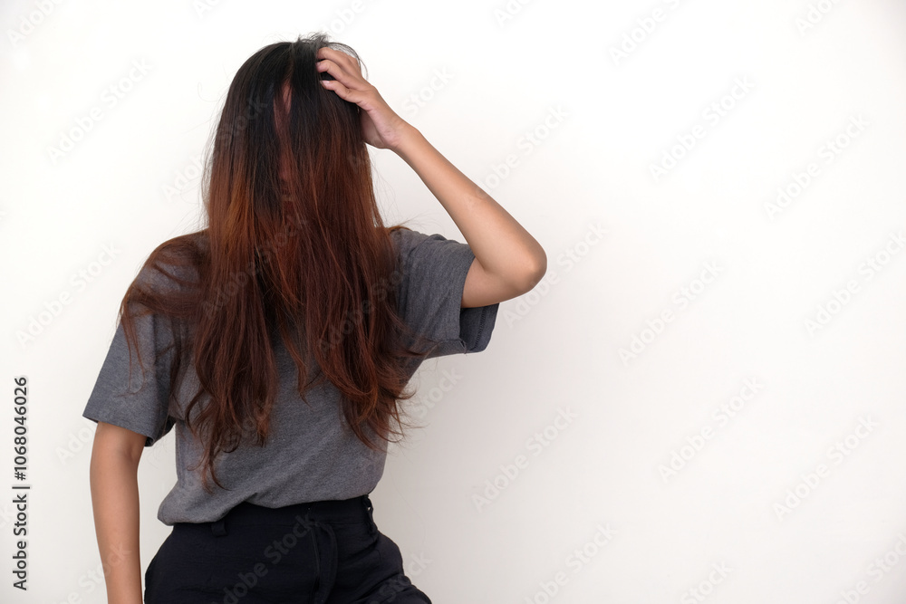 Woman with her face completely covered with her hair, scratching her scalp suffering from dandruff Woman with her face completely covered with her hair, scratching her scalp suffering from dandruff