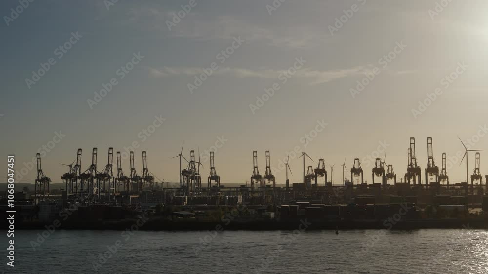 Sunset over Hamburg's bustling industrial port with silhouetted cranes. Ideal for documentaries and travel videos. Sunset over Hamburg's bustling industrial port with silhouetted cranes. Ideal for documentaries and travel videos.
