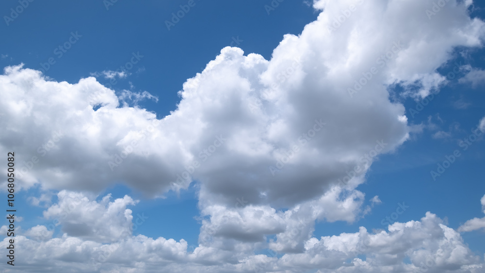 Obraz premium clear blue sky background,clouds with background, Blue sky background with tiny clouds. White fluffy clouds in the blue sky. Captivating stock photo featuring the mesmerizing beauty of the sky and cl