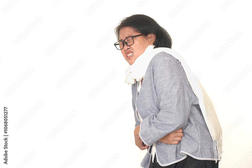 Asian middle-aged woman pressing her stomach, feeling unwell suffering from food poisoning in the office Asian middle-aged woman pressing her stomach, feeling unwell suffering from food poisoning in the office