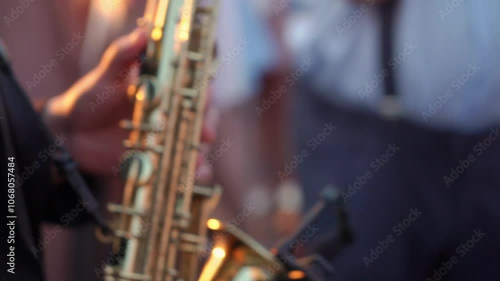 The image shows a saxophonists hand on a golden saxophone, capturing the lively essence of a jazz performance The image shows a saxophonists hand on a golden saxophone, capturing the lively essence of a jazz performance
