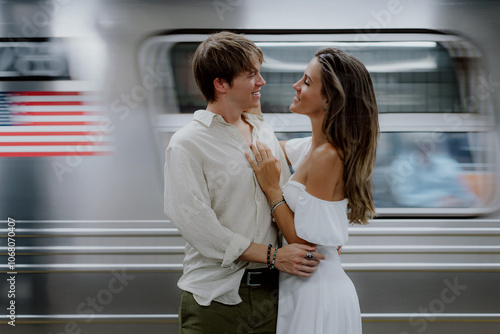 A couple shares a tender moment in a busy subway in New York, showcasing their love amidst the citys constant energy