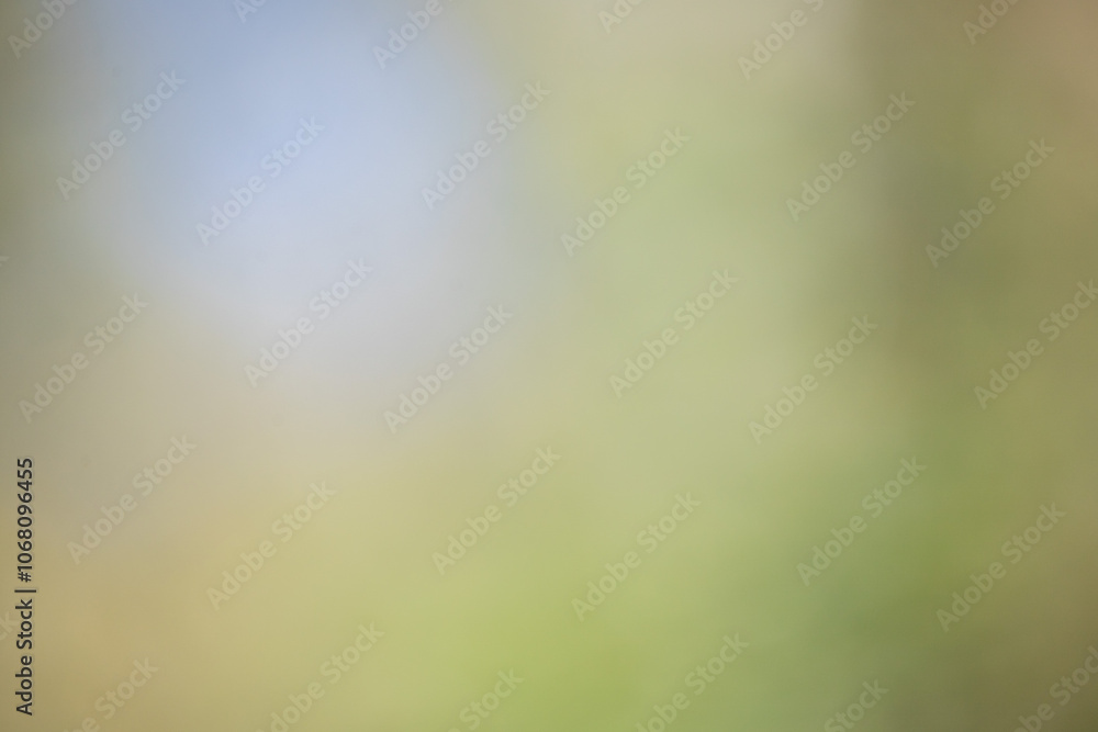 A blurry image of a green field with a blue sky in the background A blurry image of a green field with a blue sky in the background