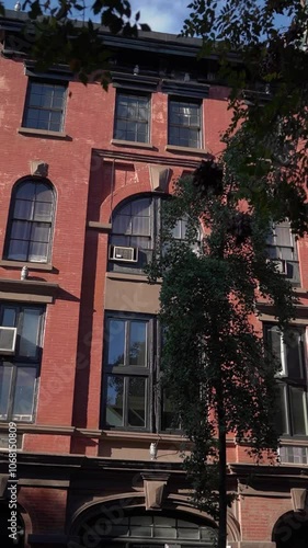 A charming red brick building facade that beautifully showcases classic architecture within a vibrant city landscape