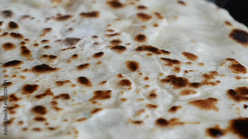 A CloseUp View of Deliciously Crispy and Flavorful Flatbread on a Black Surface Background A CloseUp View of Deliciously Crispy and Flavorful Flatbread on a Black Surface Background