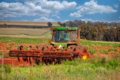 tractor with plough in the field plowing the agricultural land