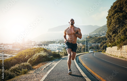 Exercise, man or outdoor with music for running, workout or cardio fitness in Brazil. Sports person, topless or earphones on road for marathon preparation, intense sprinting or training goal ambition photo