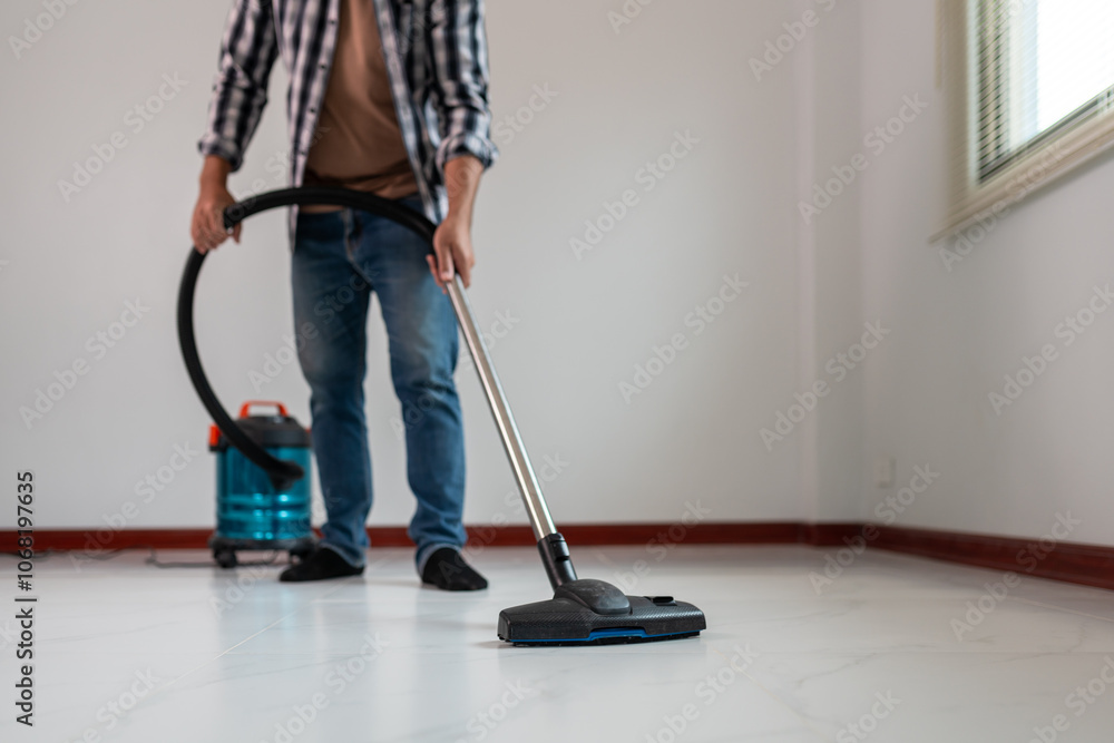 Person Vacuuming Floor with Modern Vacuum Cleaner in Clean, Minimalistic Room Person Vacuuming Floor with Modern Vacuum Cleaner in Clean, Minimalistic Room
