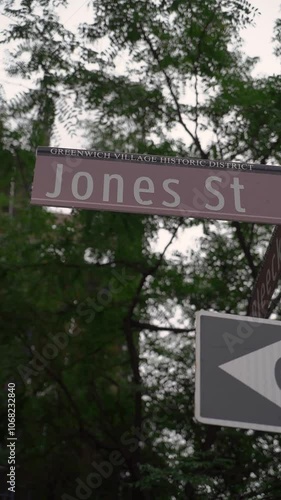 A street sign for Jones St surrounded by greenery in a bustling urban setting, showcasing vibrant city life photo