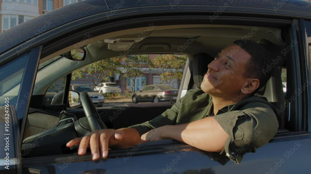 Excited attractive black male driver sitting in new vehicle, holding keyless entry key, expressing happiness and joy after purchase automobile in car dealership. Excited attractive black male driver sitting in new vehicle, holding keyless entry key, expressing happiness and joy after purchase automobile in car dealership.