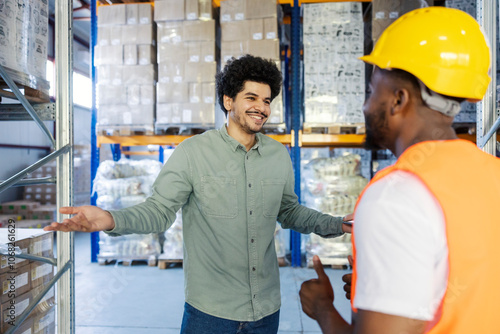 Diverse storage manager explaining to his black migrant blue collar worker his assignments.