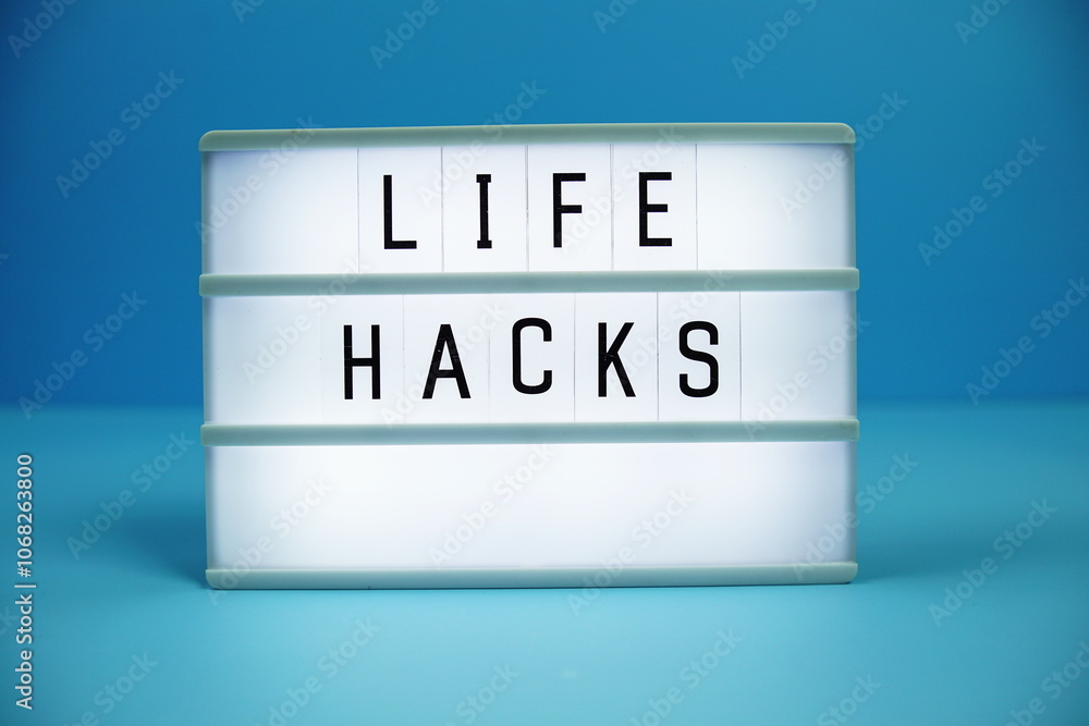 Life Hacks letterboard text on LED Lightbox on blue background Life Hacks letterboard text on LED Lightbox on blue background