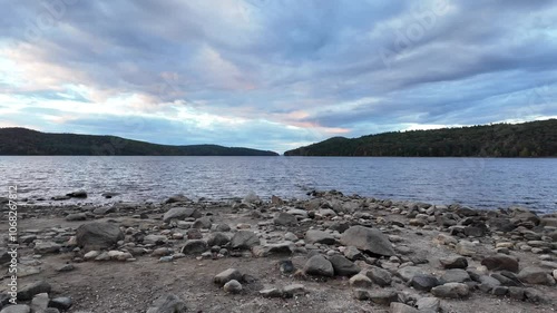 The pebble banks of Quabbin Reservoir in the foreground, with hills and forest in the background. photo