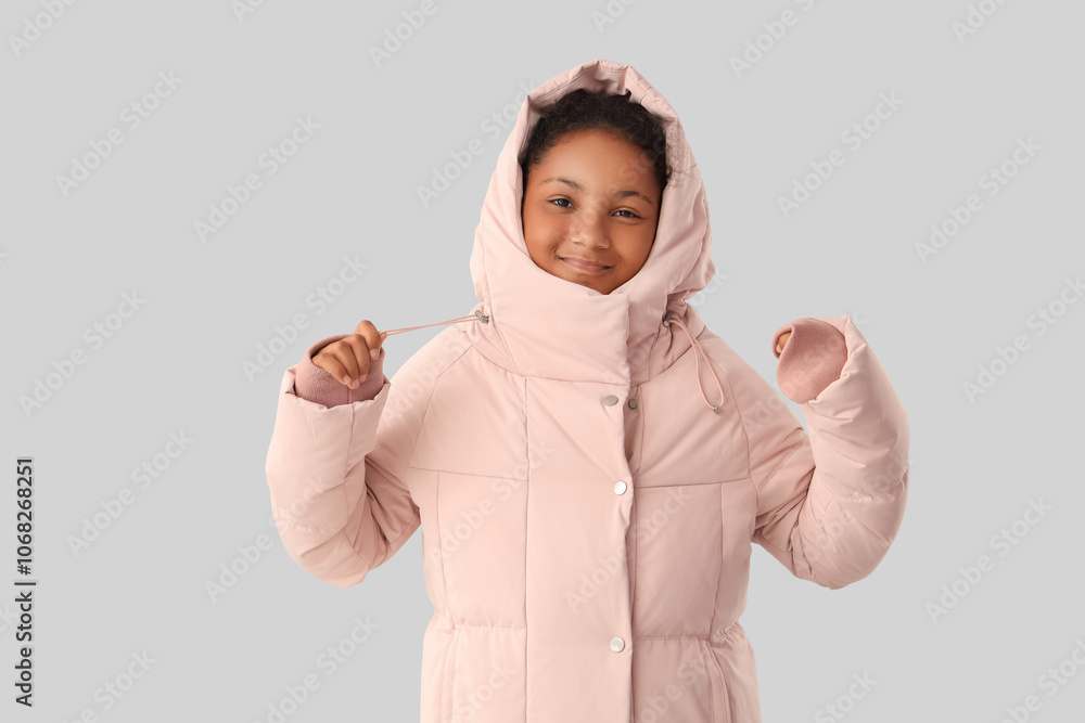 Cute African-American girl in stylish pink jacket on grey background Cute African-American girl in stylish pink jacket on grey background