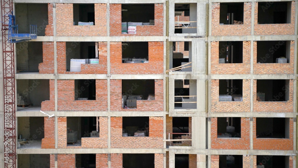 Construction site showing building frame and red bricks during construction process Construction site showing building frame and red bricks during construction process