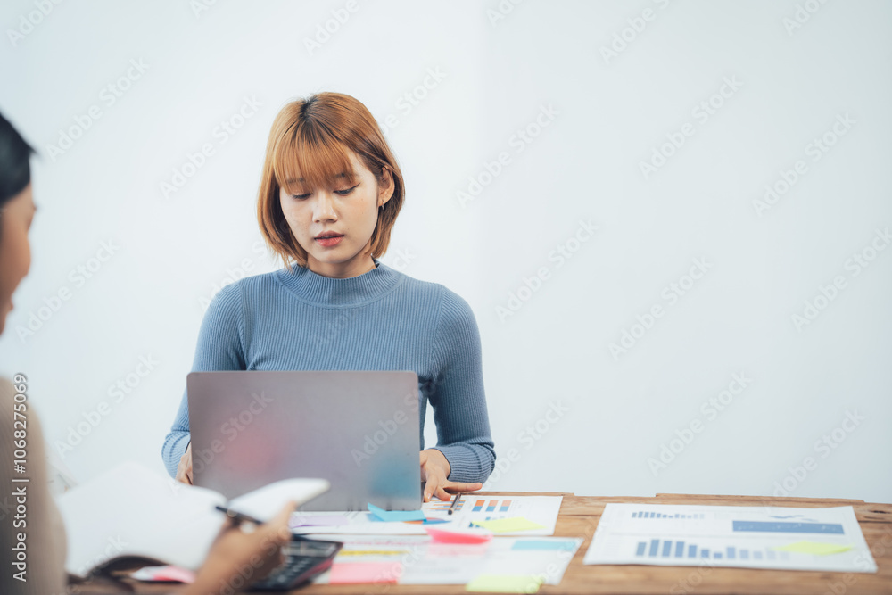 Strategic Collaboration: A focused businesswoman reviews data on her laptop during a collaborative work session, showcasing meticulous planning and teamwork. Strategic Collaboration: A focused businesswoman reviews data on her laptop during a collaborative work session, showcasing meticulous planning and teamwork.