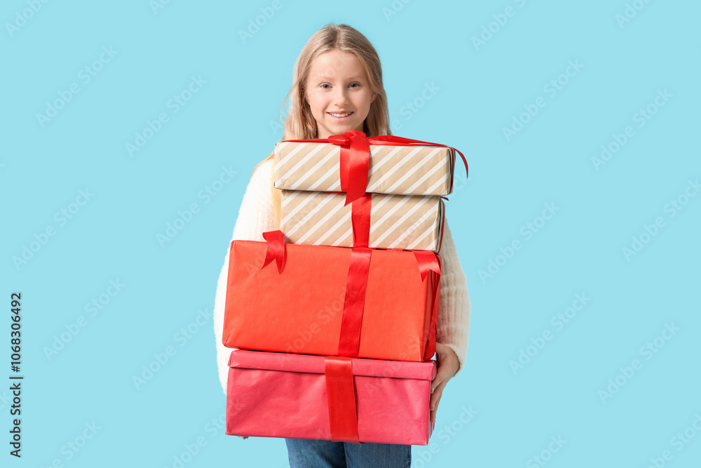 Cute girl with gift boxes on blue background. Christmas celebration Cute girl with gift boxes on blue background. Christmas celebration