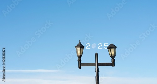 Street lamps with 2025 under blue sky.