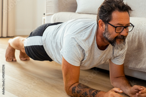 The man engages in his regular fitness routine on the floor of his home, dressed in casual athletic wear, focusing on body conditioning, wellness, and personal growth while pursuing weight loss 