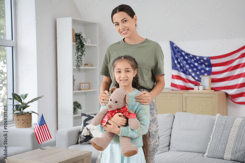 Female soldier and her daughter with toy bear at home Female soldier and her daughter with toy bear at home