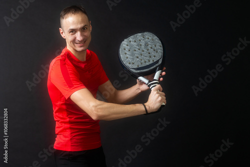 Man plays paddle tennis and poses in studio photos on white black background photo