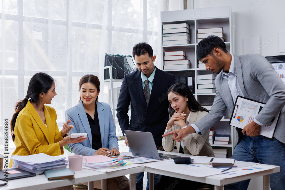 Group of confident business asian people point to graphs and charts to analyze market data, balance sheet, account, net profit to plan new sales strategies to increase production capacity. Group of confident business asian people point to graphs and charts to analyze market data, balance sheet, account, net profit to plan new sales strategies to increase production capacity.