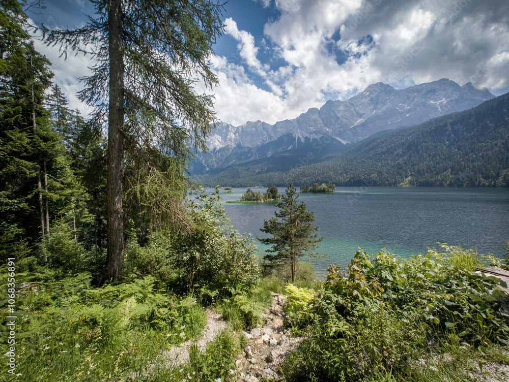 Sunny summer panorama of the Eibsee lake with Zugspitze mountain range. Splendid outdoor scene in German Alps, Bavaria, Garmisch-Partenkirchen village location, Germany, Europe. Sunny summer panorama of the Eibsee lake with Zugspitze mountain range. Splendid outdoor scene in German Alps, Bavaria, Garmisch-Partenkirchen village location, Germany, Europe.