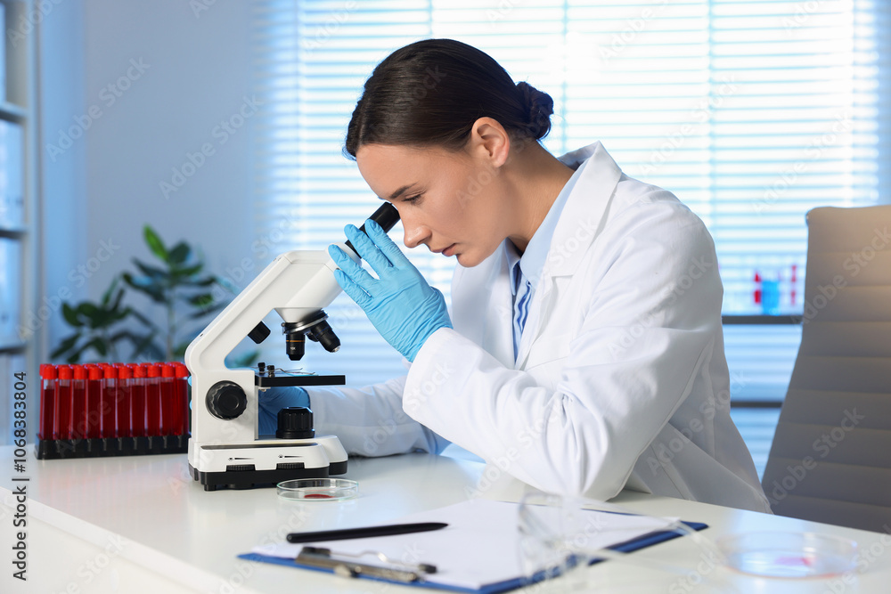 Laboratory testing. Doctor working with microscope at table indoors Laboratory testing. Doctor working with microscope at table indoors