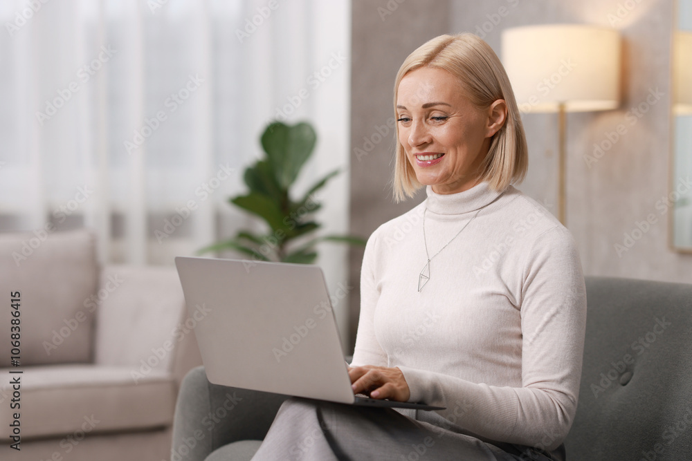 Smiling middle aged woman working with laptop on sofa at home Smiling middle aged woman working with laptop on sofa at home