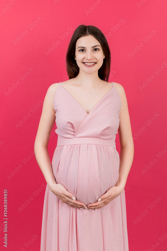 Happy pregnant woman touching her abdomen at Colored background. Future mother is wearing white underwear. Expecting of a baby. Copy space Happy pregnant woman touching her abdomen at Colored background. Future mother is wearing white underwear. Expecting of a baby. Copy space