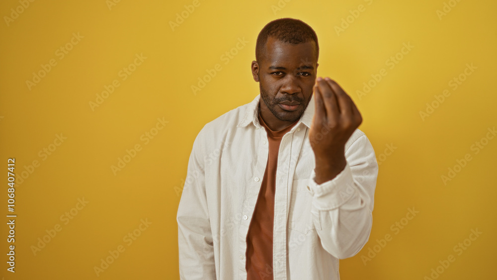 Young man making italian hand gesture against a vibrant yellow background, embodying style and charisma. Young man making italian hand gesture against a vibrant yellow background, embodying style and charisma.