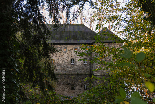 Old stone mill on the bank of a river in autumn, 