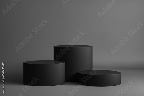 Three black cylindrical podiums on a grey background