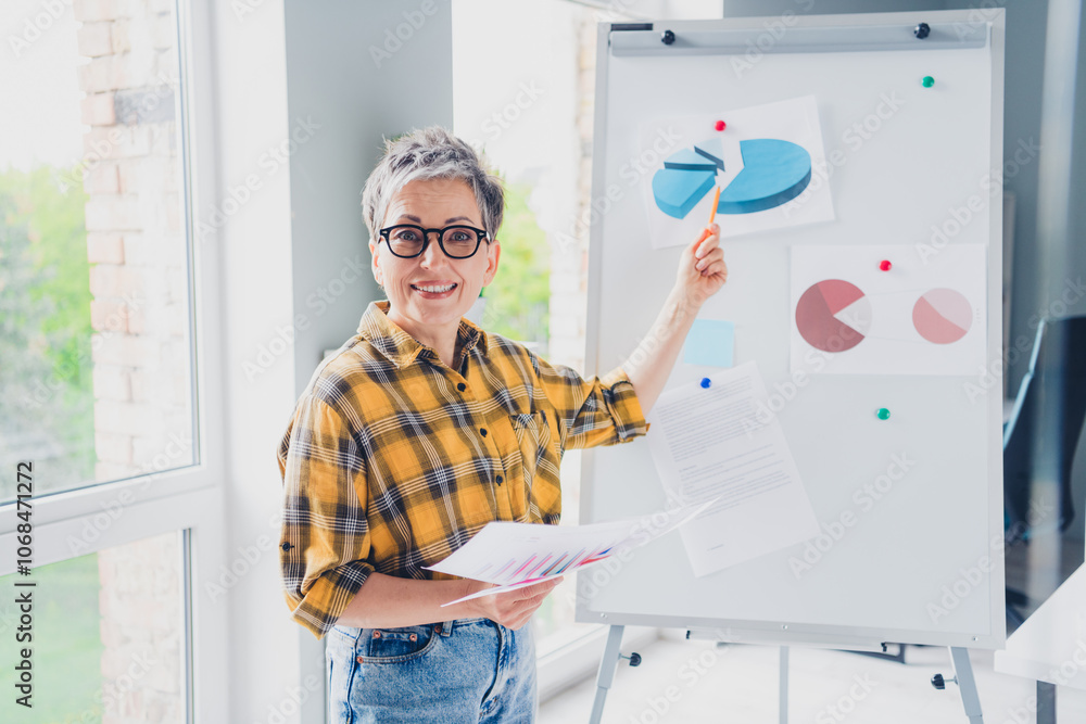 Photo of lovely pensioner lady boardroom presentation dressed plaid yellow shirt comfortable startup office room interior Photo of lovely pensioner lady boardroom presentation dressed plaid yellow shirt comfortable startup office room interior